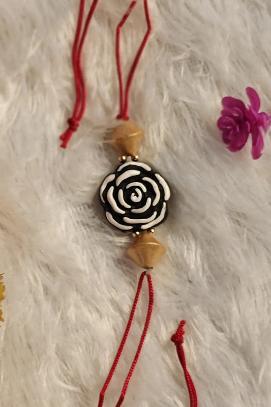 Black and white rose terracotta rakhi with wooden beads – handmade Bengal clay Raksha Bandhan thread by Bong Trendz