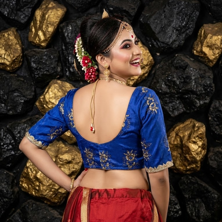 Macro shot of golden zari floral thread work on premium blue silk fabric.