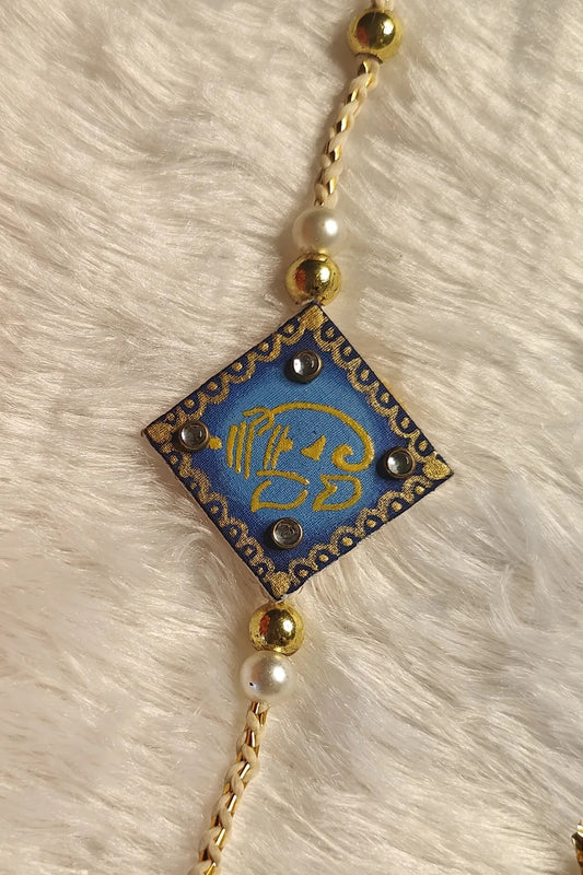 Hand-painted Ganesha fabric rakhi in royal blue with pearls – auspicious Raksha Bandhan thread by Bong Trendz