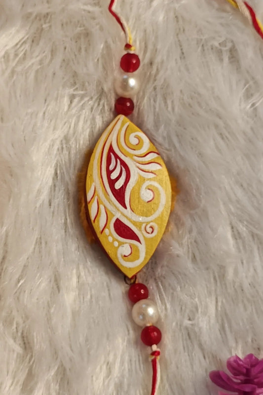 Hand-painted paisley terracotta rakhi in yellow with pearls – Bengal clay Raksha Bandhan thread by Bong Trendz