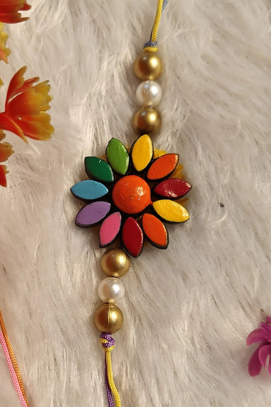 Multicolour floral terracotta rakhi with gold and pearl beads – handmade Bengal clay Raksha Bandhan thread by Bong Trendz