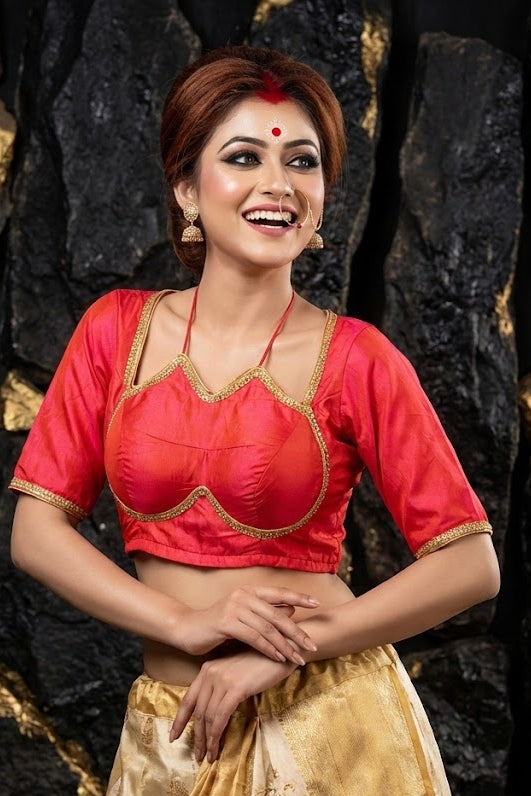 Front view of strawberry pink glazy silk blouse with gold Masaba style foil print and lace border