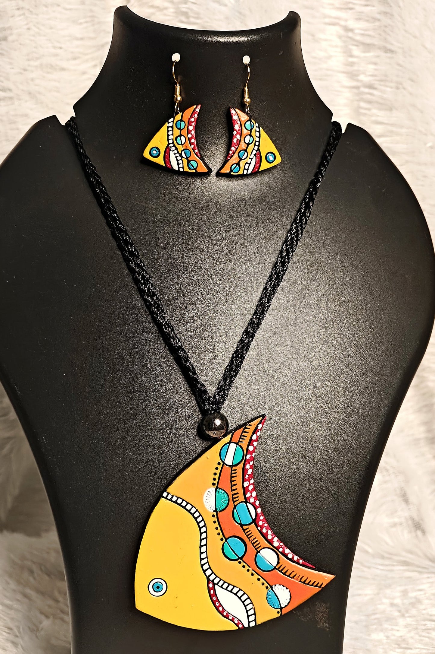 Close-up of hand-painted Pattachitra fish terracotta pendant in yellow-orange-turquoise - Bong Trendz