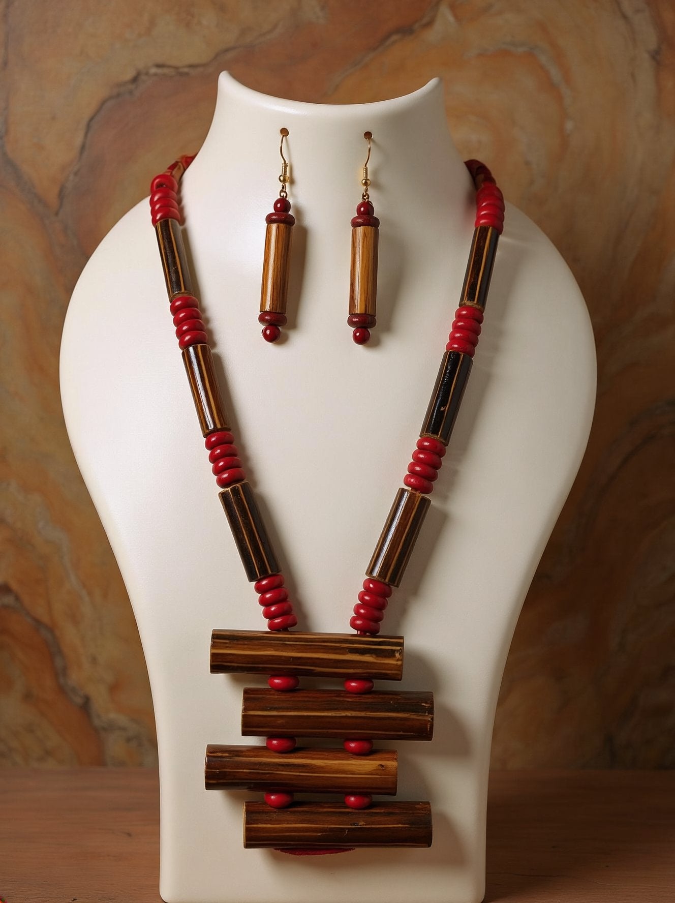 Tribal bamboo necklace with stacked bamboo tube ladder pendant, red wooden beads and matching bamboo tube earrings on a white bust