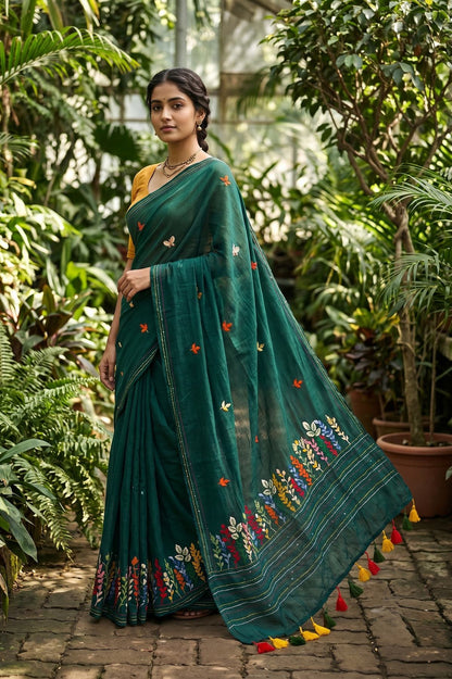 Woman wearing bottle green Belpotra pure mul cotton saree with bullion stitch bael leaf embroidery in a garden setting
