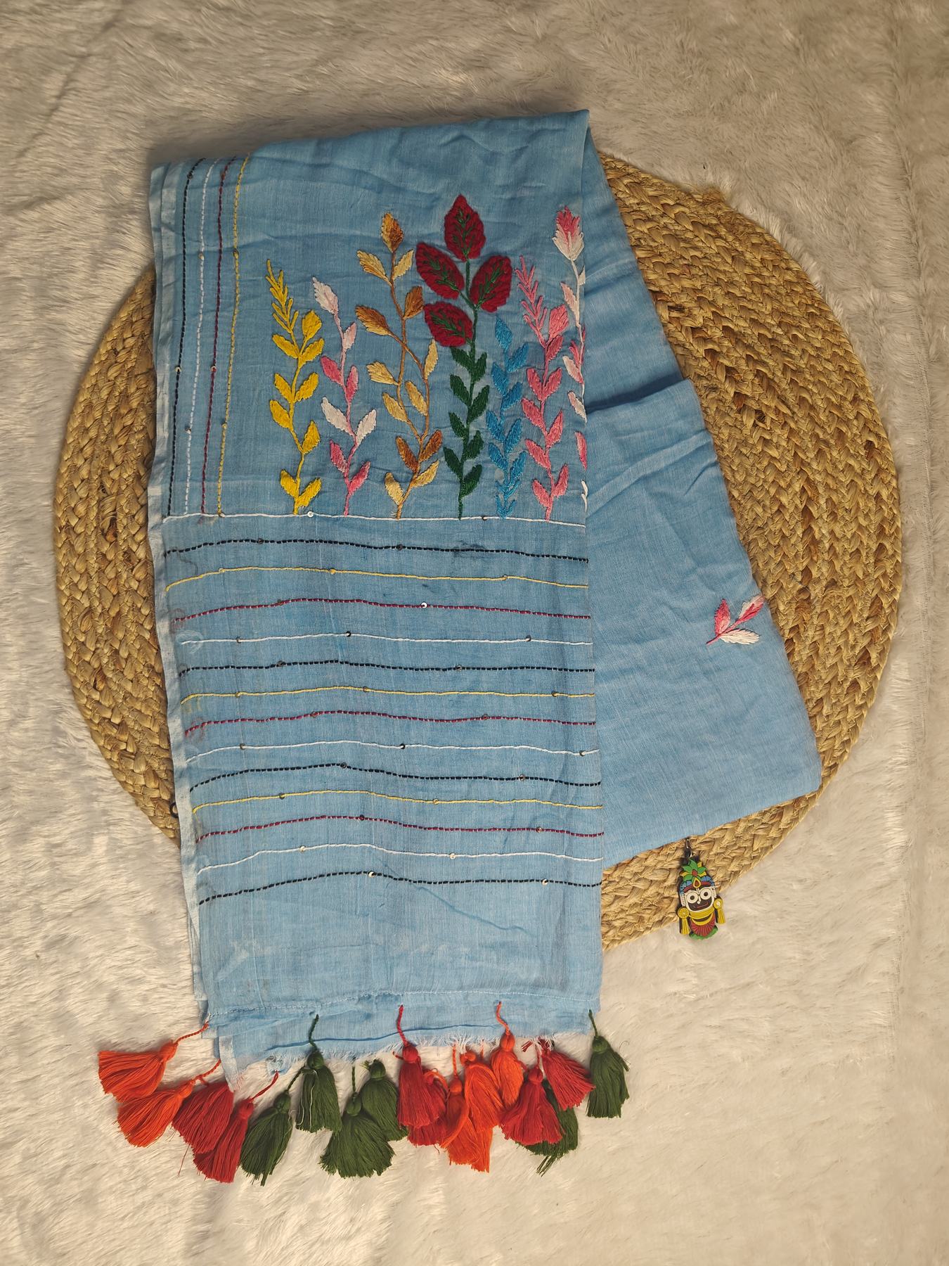 Sky blue Belpotra pure mul cotton saree flatlay showing bullion stitch bael leaf and butterfly embroidery with sequin-dotted pallu