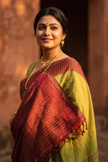 Noyontara handloom cotton saree in Mehendi Green with Maroon Kajur Chhari border, close-up portrait with gold jewellery