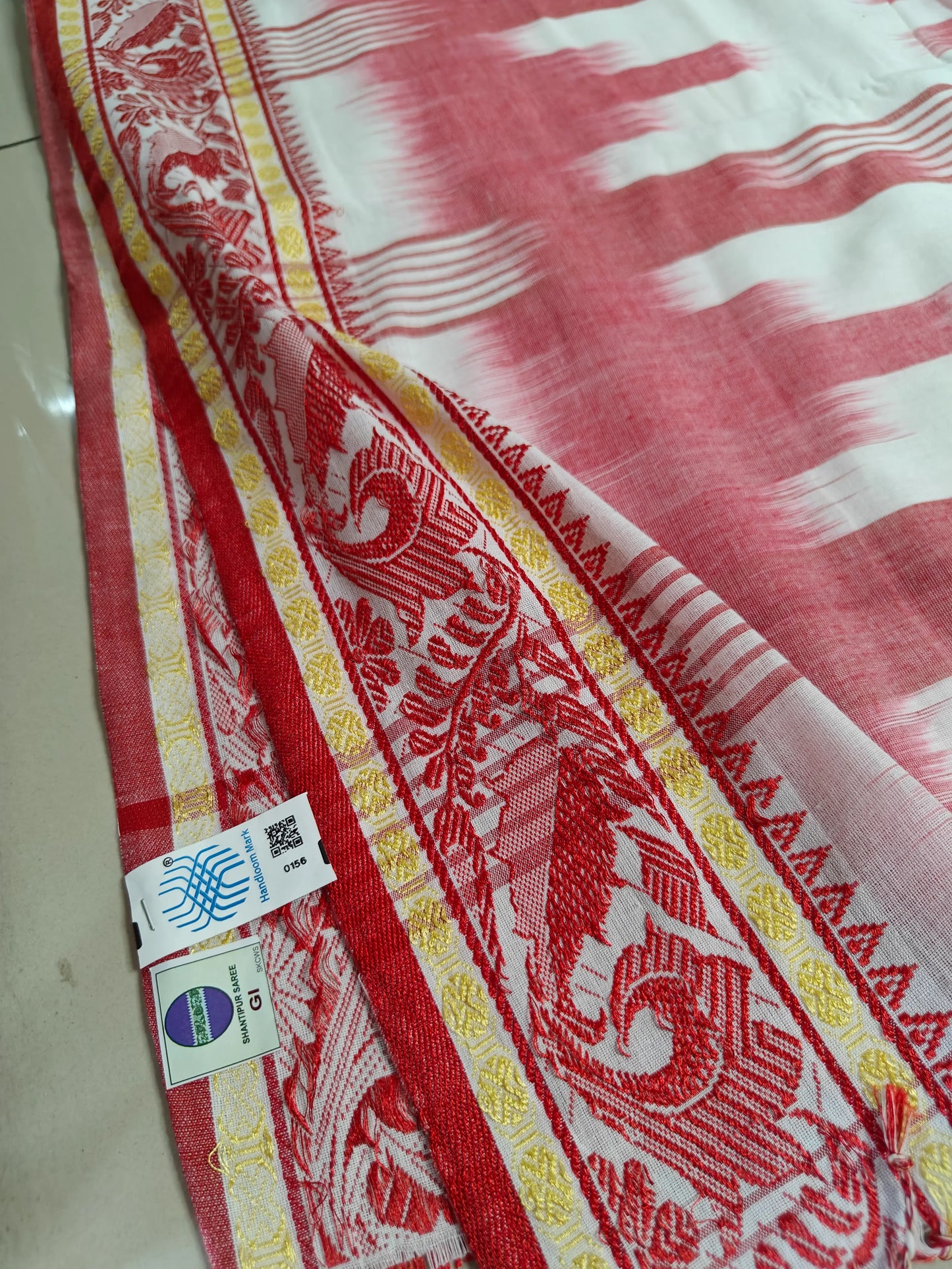 Close-up of India Handloom Mark and Shantipur GI tag label stitched on the cotton saree