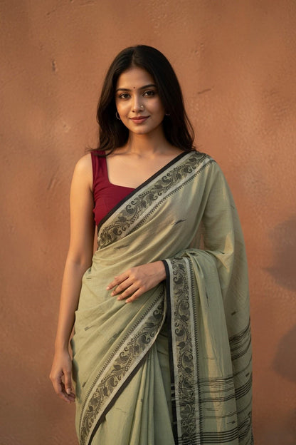 Konika olive green Shantipur handloom cotton saree draped side view with maroon blouse and black floral border