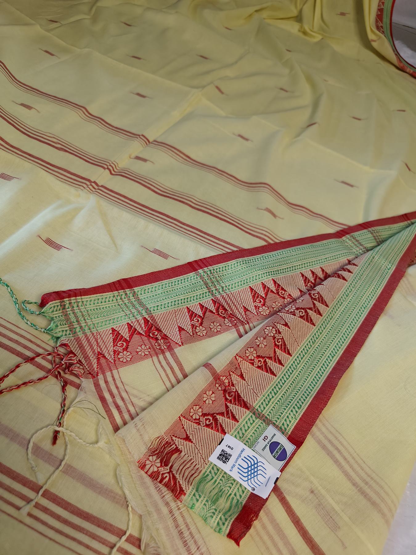 Konika yellow Shantipur cotton saree GI tag and Handloom Mark label close-up, real product photo