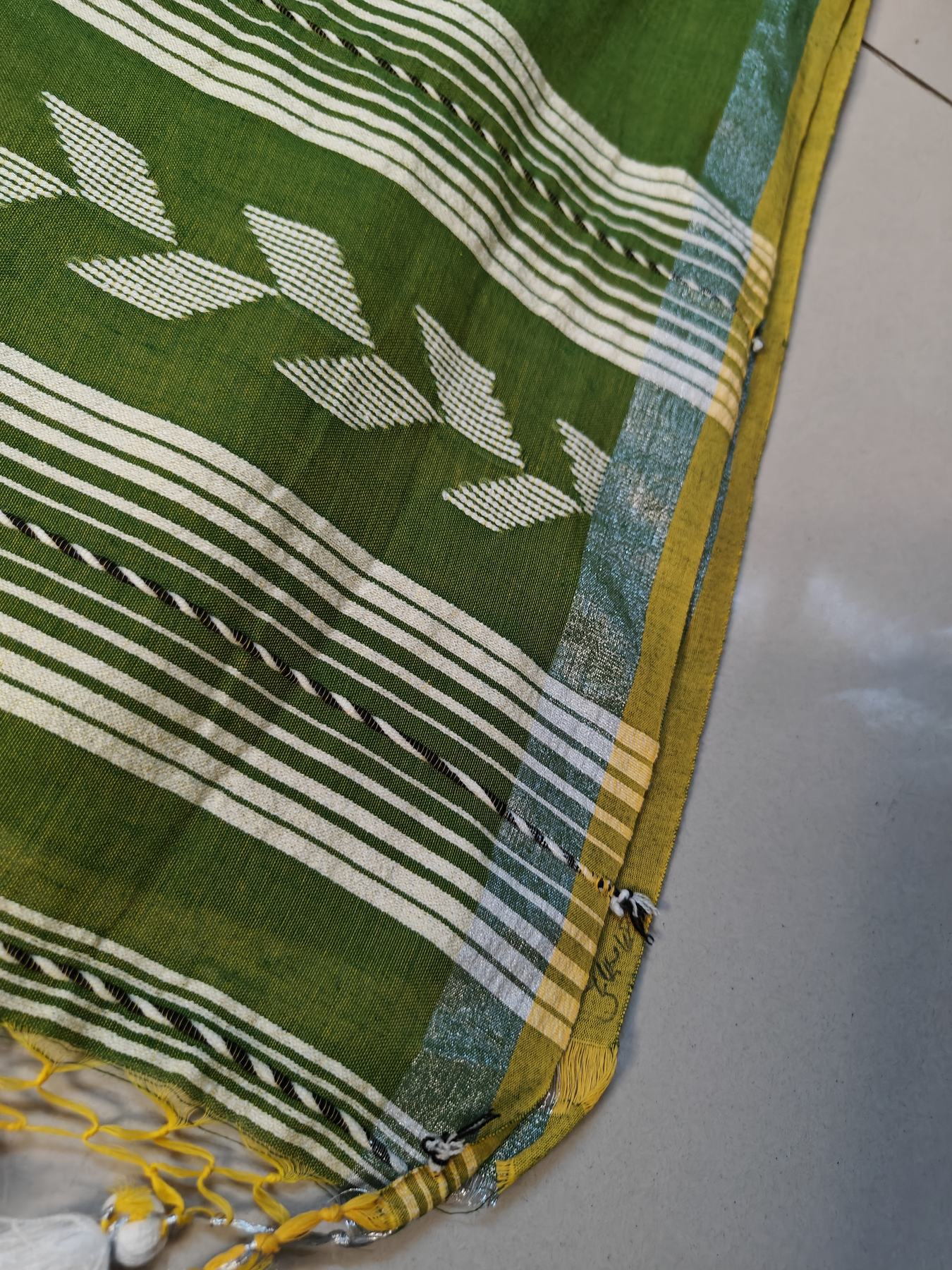 Close-up of the green Tirlata saree's arrow buti chevron border