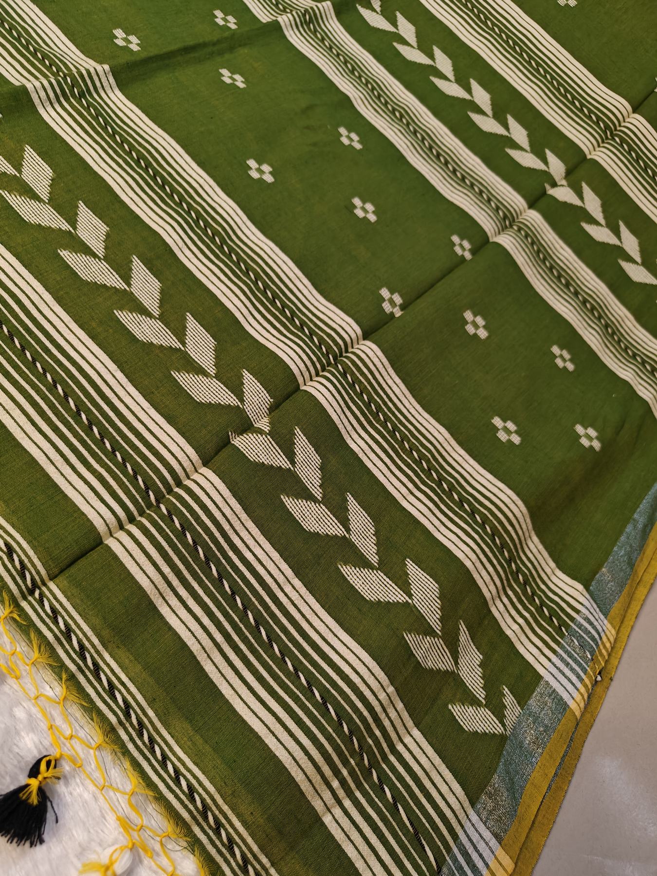 Close-up of the green Tirlata saree's all-over flower butti weave